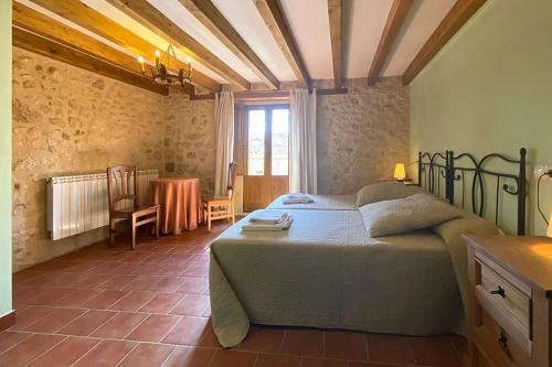 ein Schlafzimmer mit einem Bett und einem Tisch in einem Zimmer in der Unterkunft La Marcela in Peñalba de San Esteban