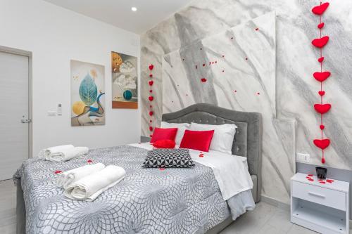 a bedroom with a bed with red hearts on the wall at Pm House in Misterbianco