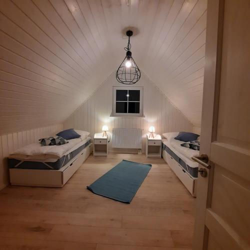 a room with two beds and a chandelier at Haus Abendsonne in Wandlitz