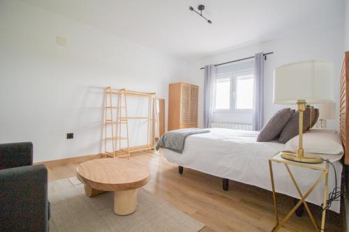 a bedroom with a bed with a lamp and a table at La Casa del Alcalde in Ceguilla