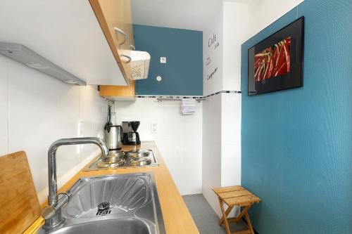 a kitchen with a sink and a tv on the wall at Ferienwohnung Sonnenring in Rüthen