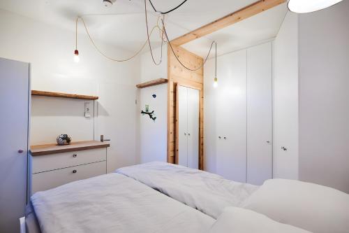 a bedroom with white walls and a bed with white sheets at Einzigartige Tischlerwohnung in Oldenburg