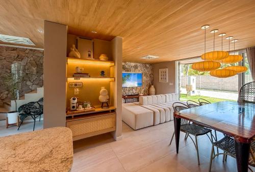 a living room with a table and a couch at Casa Verde Mar Naluum in Passo de Camarajibe