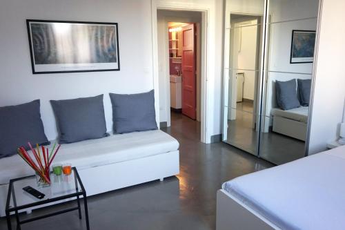 a living room with a white couch and a mirror at KYMA Apartments - Athens Acropolis 8 in Athens