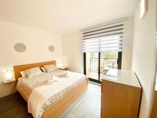 a bedroom with a bed and a large window at Atico Solarium La Cala in Miami Platja