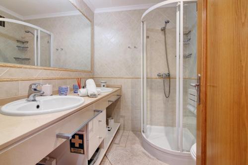 a bathroom with a sink and a shower at Vilamoura Golfe Mar in Quarteira
