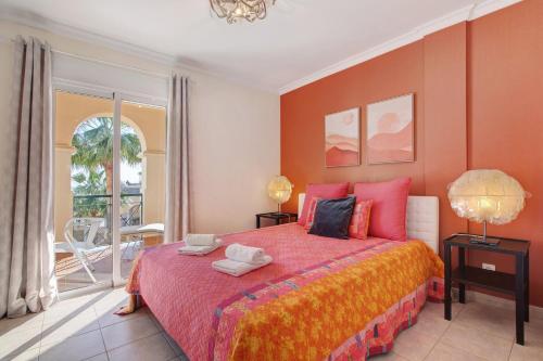 a bedroom with a large bed with orange walls at Vilamoura Golfe Mar in Quarteira