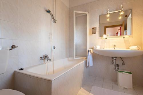 a bathroom with a tub and a sink and a toilet at Sabina Dolomites Zirbel in Alpe di Siusi