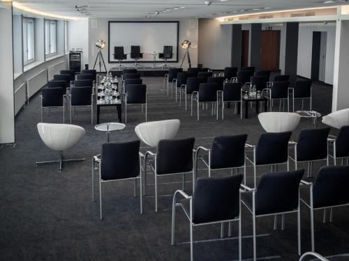 a conference room with chairs and tables and a screen at Radisson Blu Hotel, St. Gallen in St. Gallen