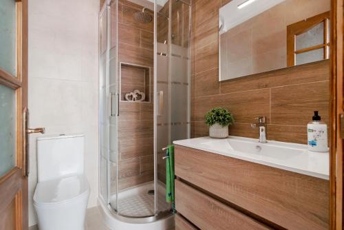 a bathroom with a shower and a sink and a toilet at Casa Paca in Maspalomas
