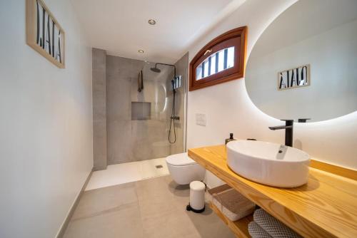 a bathroom with a sink and a toilet and a mirror at Mar in Playa Honda