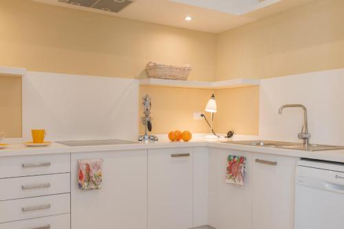 a kitchen with white cabinets and oranges on the counter at Villa Muscari in Benalup Casas Viejas