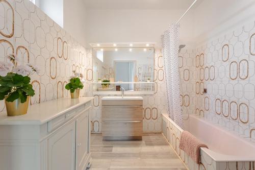 a white bathroom with a sink and a mirror at Chambre d'hote Rubis in Genouillé