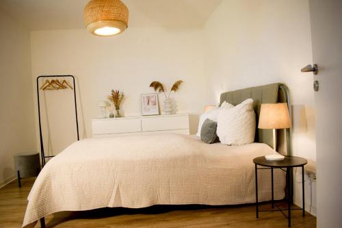 a bedroom with a bed with a white bedspread at Fewo Tenne in Menslage
