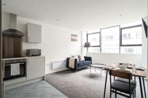a kitchen and living room with a table and a couch at Fantastic Central Preston 1 Bedroom Apartment in Preston