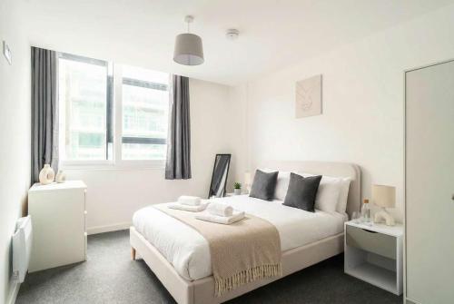 a white bedroom with a bed and a window at Fantastic Central Preston 1 Bedroom Apartment in Preston