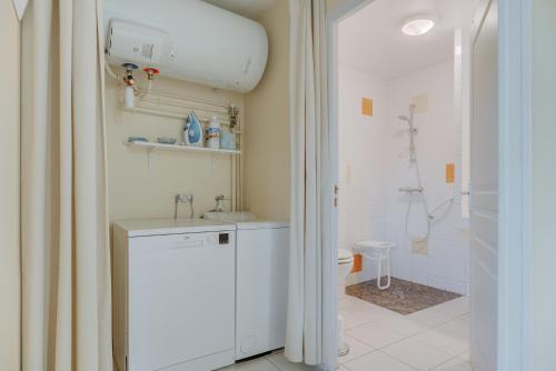 a bathroom with a toilet and a sink and a shower at Grain de vanille in Saint-Benoît-des-Ondes