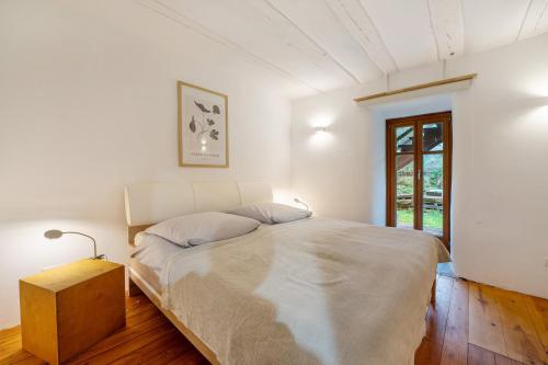 a white bedroom with a large bed and a window at Alte Mühle in Dernbach in Dernbach