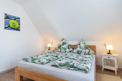 a bedroom with a bed with green sheets and pillows at Ferienwohnung Leon in Kappel-Grafenhausen