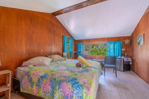a bedroom with a bed and a desk in a room at Matira house in Bora Bora