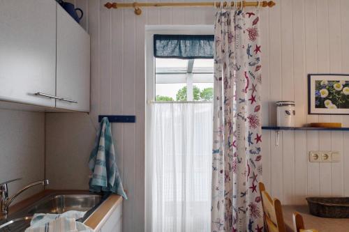 a kitchen with a sink and a window at Möve Aba Bungalow 63 in Rerik