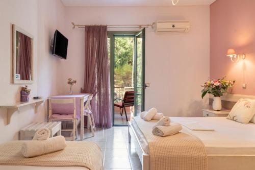 a hotel room with two beds and a table and a window at Nontas Home 27 in Kalamitsi