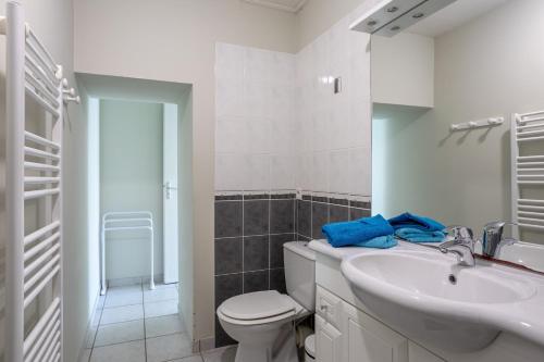 a white bathroom with a toilet and a sink at Maison proche océan - 6 pers in Bretignolles-sur-Mer
