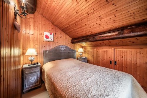 a bedroom with a bed in a wooden room at Appartement chalet - Le Vnipi in Abondance
