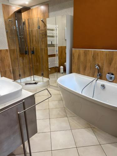a bathroom with two sinks and a tub and a shower at Serviced Apartments Xanthurus in Schwelm