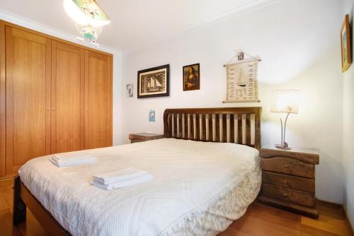 a bedroom with a bed with two towels on it at Casa da Mãe Maria in Buarcos