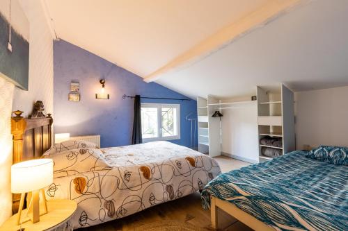 two beds in a room with blue walls at Gite Senguinous 1 in Lesparre-Médoc