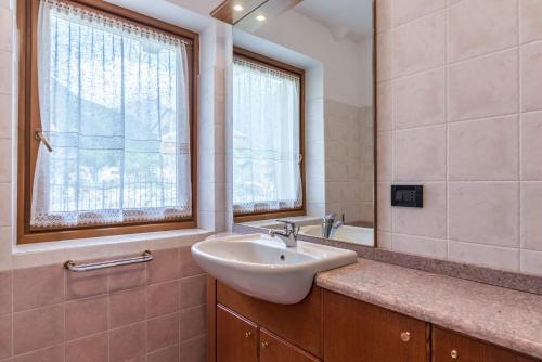 a bathroom with a sink and a window at Appartamento Adamello Casa Lucia in Pinzolo