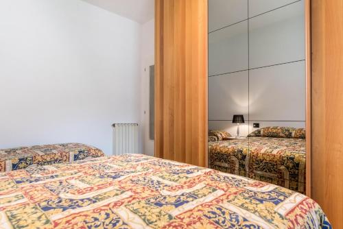 a bedroom with two beds and a mirror at Appartamento Adamello Casa Lucia in Pinzolo