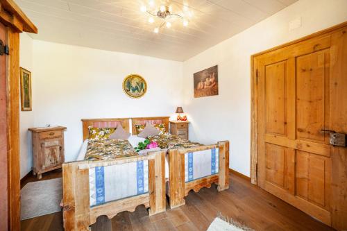 a bedroom with two beds and a wooden door at Sagschneiderhof Golden Delicious in Plaus