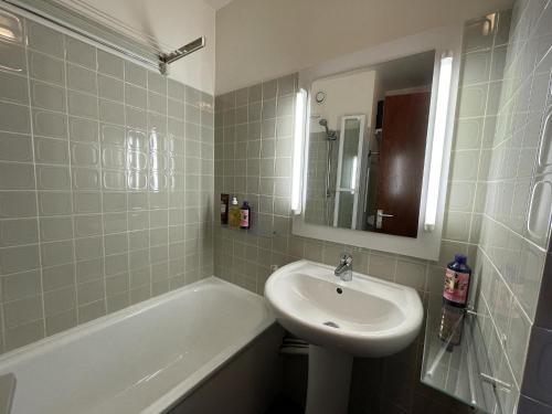 a bathroom with a sink and a bath tub at Brelin - Combes in Les Menuires