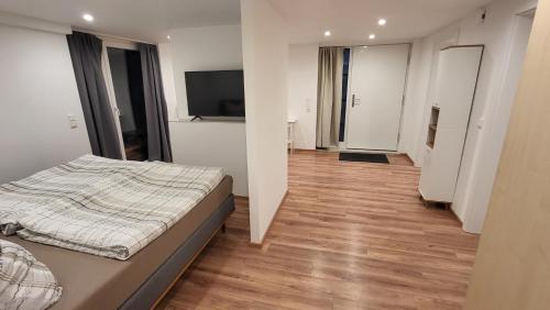 a bedroom with a bed and a flat screen tv at Ferienwohnung Burgstraße in Fuldatal