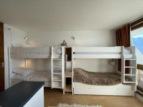 a bedroom with two bunk beds and a desk at Brelin - Combes in Les Menuires