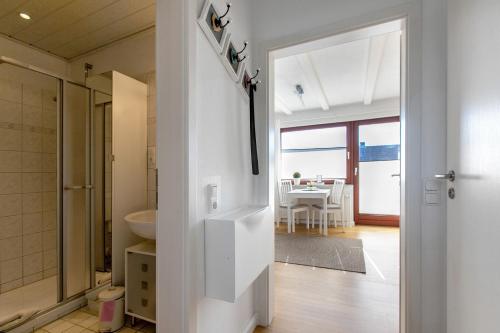 a bathroom with a door open to a dining room at Haus am Hemm in Meldorf