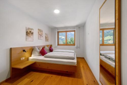 a small bedroom with a bed and a mirror at Tholerhof in Schenna