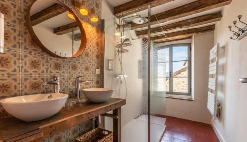 a bathroom with two sinks and a mirror at Gîte La voisine in Venteuil