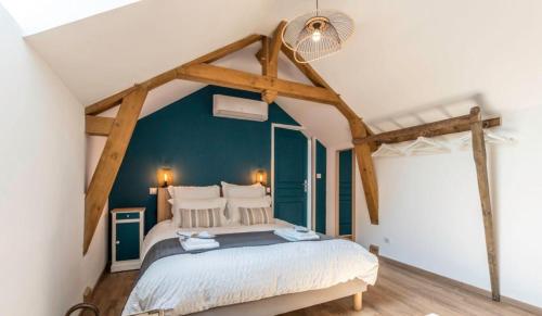 a bedroom with a bed with a blue wall at Gîte La voisine in Venteuil