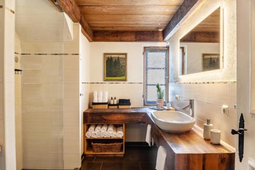 a bathroom with a sink and a mirror and a shower at Ferienwohnung siebzehn35 in Garmisch-Partenkirchen