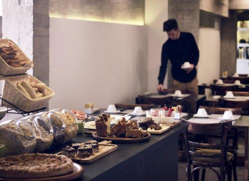 a man standing behind a table with plates of food at InnAthens in Athens