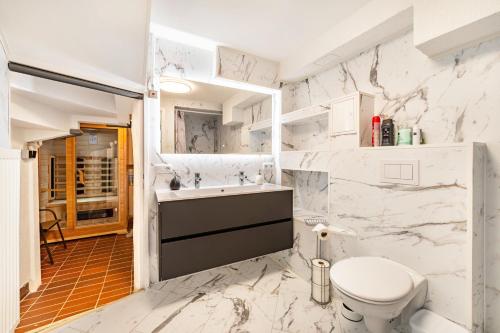 a white bathroom with a toilet and a sink at Ferienhaus bei Reichsburg Cochem in Cochem