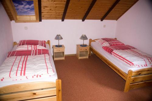 two beds in a room with two lamps on tables at Rauber Marie Theres in Abentheuer