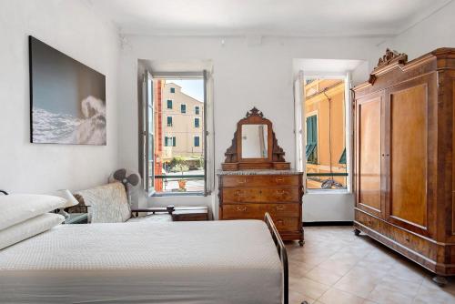 a bedroom with a bed and a dresser and a mirror at Appartamento Piazza Bertamino in Bonassola