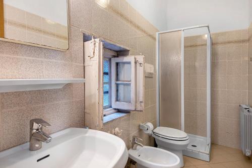 a bathroom with a sink and a toilet and a window at Appartamento Piazza Bertamino in Bonassola