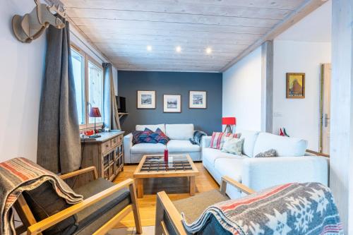 a living room with a couch and a table at Chalet du Fey in Valmorel