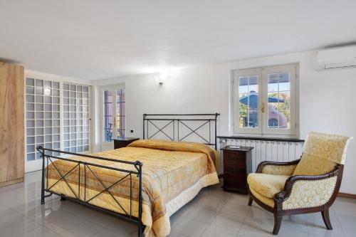 a bedroom with a bed and a chair at Villa Lucia in Ameglia