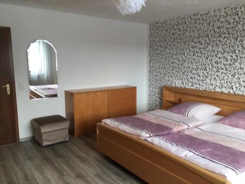 a bedroom with a large bed and a mirror at Ferienwohnung Waldhütter in Schwarzenbach an der Saale